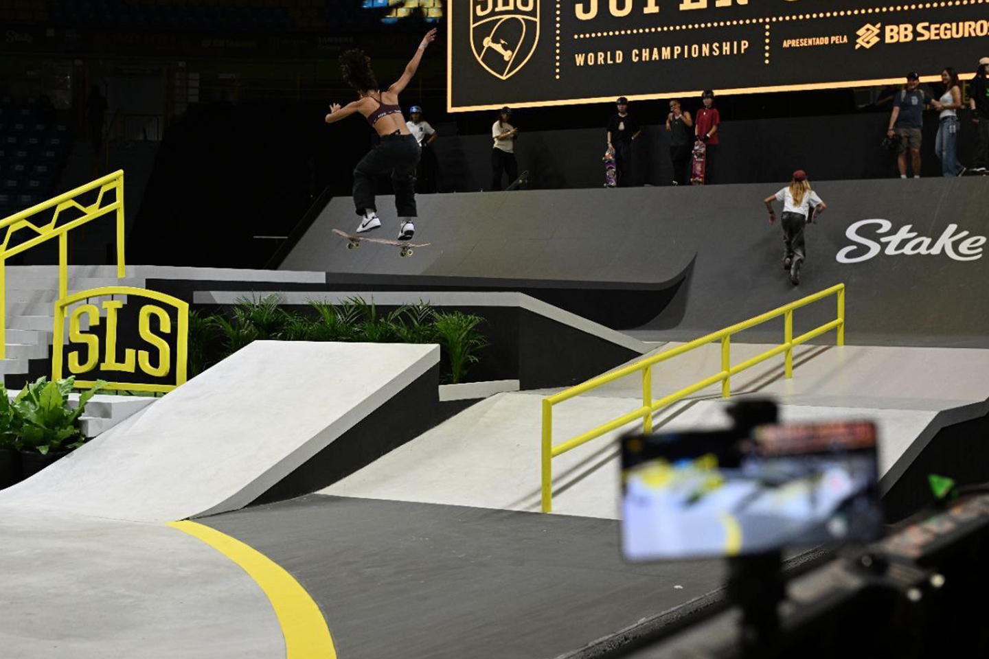 An image carousel features a Galaxy S25 mounted near the SLS Super Crown World Championship stage as it captures a skateboarder’s moves during a routine.