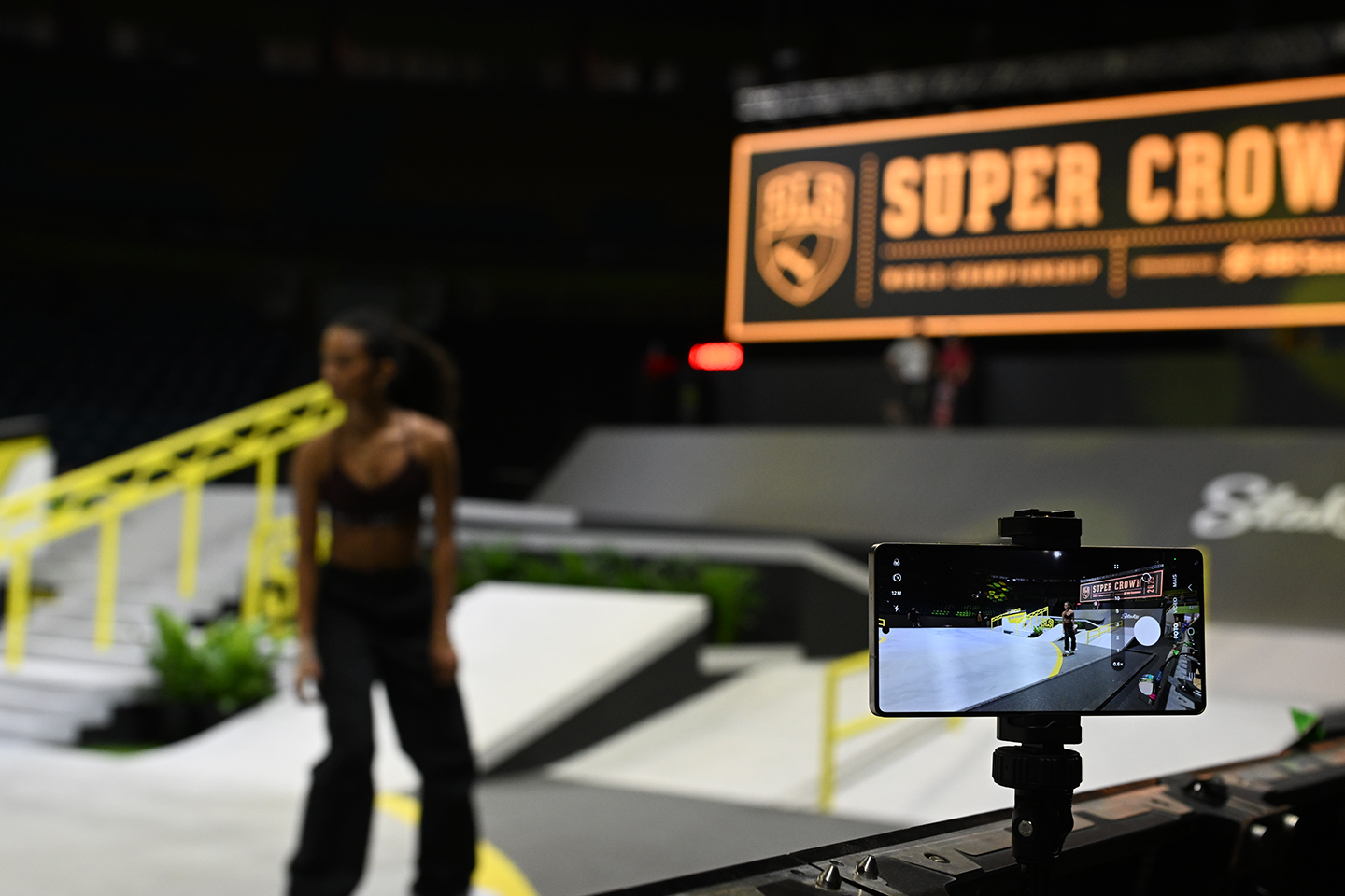 An image carousel features a Galaxy S25 mounted near the SLS Super Crown World Championship stage as it captures a skateboarder’s moves during a routine.