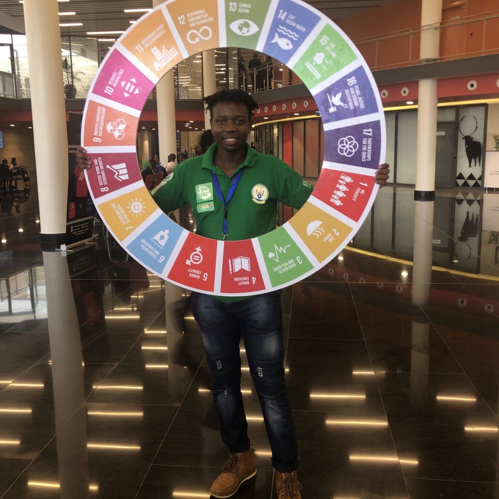Generation17 Young Leader Tafara Makaza holds up a wheel logo showing the 17 SDGs